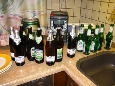 Bierflaschen und ein Partyfass auf einer Küchenarbeitsplatte.